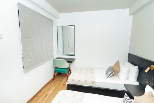 a bedroom with two beds and a chair at Altitude Ambuluwawa in Gampola