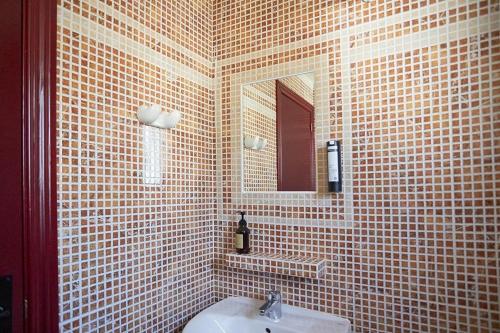 a tiled bathroom with a sink and a mirror at Camping Taiga Lake Caspe - Maeva Vacansoleil in Caspe