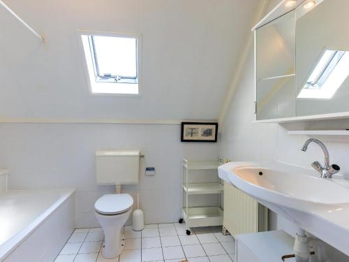 a white bathroom with a sink and a toilet at Park Brekkense Wiel 190 in Lemmer