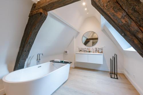 a bathroom with a large white tub and a mirror at Bright Duplex near Antwerp Cathedral in Antwerp