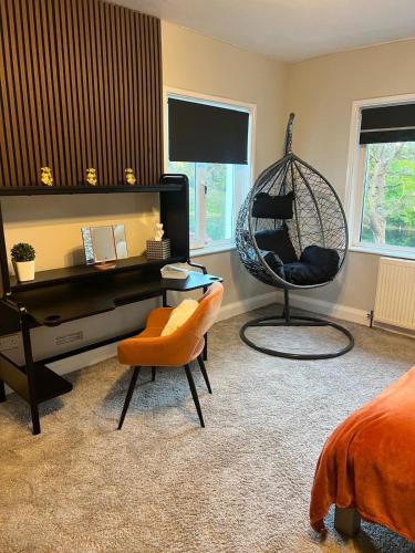 a bedroom with a swing chair and a desk at Greenways House in Lancaster