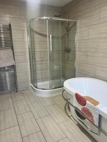 a bathroom with a bath tub and a shower at Greenways House in Lancaster