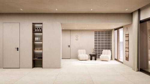 a lobby with two white chairs and a table at Tinos Beach Hotel in Kionia