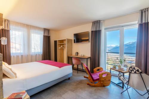 a hotel room with a bed and a desk and a window at Hirondelle Locanda Vegana in Aosta
