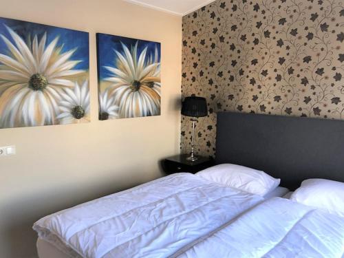 a bedroom with a bed and two pictures on the wall at Aquaronde 073 in Lemmer