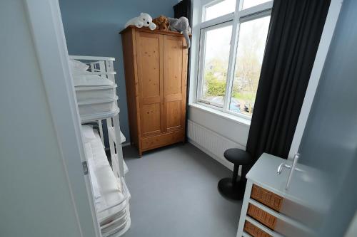 a room with a window and a bed and a shelf at Park Brekkense Wiel 103 in Lemmer