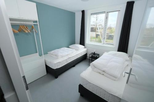 a small room with two beds and a mirror at Park Brekkense Wiel 103 in Lemmer