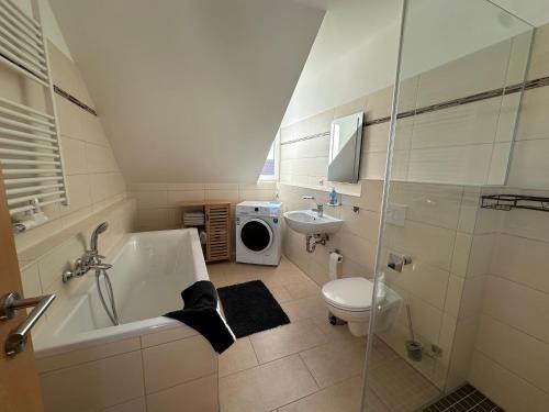 a bathroom with a tub and a toilet and a sink at Ferienhaus Weimarer Land in Berlstedt