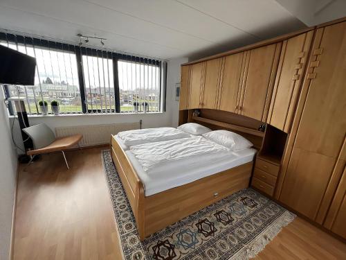 a bedroom with a bed and a large window at Park Brekkense Wiel 037 in Lemmer