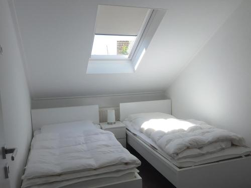 a white room with two beds and a window at Park De Markol River House in Lemmer
