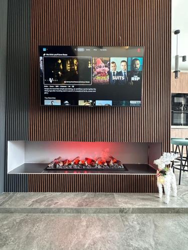a large tv on a wall with a fire place at X2 4Rest Bakuriani in Bakuriani