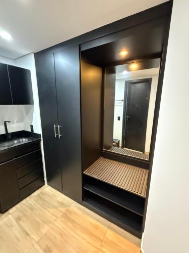 a bathroom with a walk in closet with a mirror at Hotel Sol Alphaville1505 in Barueri