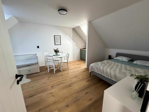 a bedroom with a bed and a table with chairs at Šťastná 118 in Sněžné