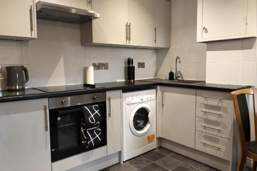 a kitchen with a washer and a washing machine at Oliver Wests Beautiful 2 Bedroom Sleeps 4 Apartment in Scarborough