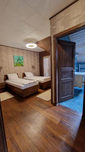 a large room with two beds and a door at Pensiunea Terra Nova in Brezoi