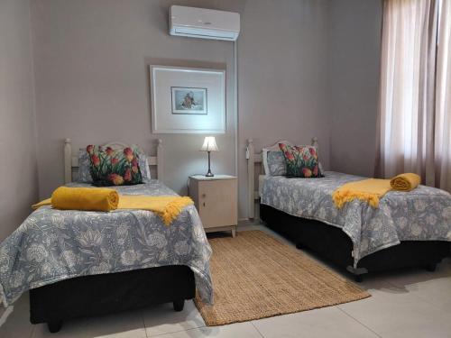 a bedroom with two beds and a lamp in it at OppiDam Gastehuis in Vanderkloof