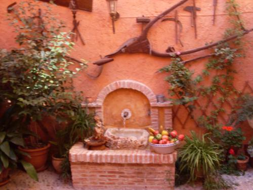 a garden with a fountain and a bowl of fruit at Hotel Casa Rural San Antón in Chinchón