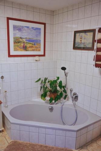 a bathroom with a bath tub with a plant in it at Ferienhaus Vogtland mit Sauna und Hot Tub in Weischlitz