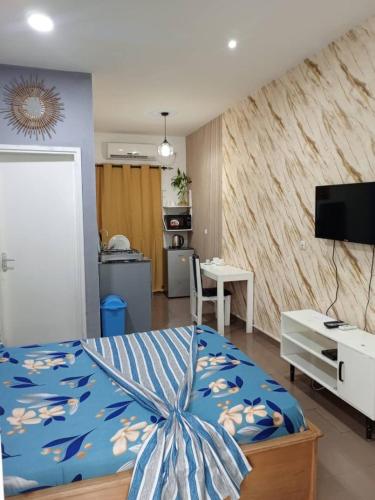 ein Schlafzimmer mit einem Bett mit blauer Bettdecke in der Unterkunft La Résidence Vanessa in Pointe-Noire