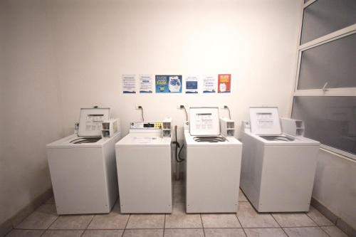 three washing machines are lined up in a room at Departamentos Alto Libertad in Viña del Mar