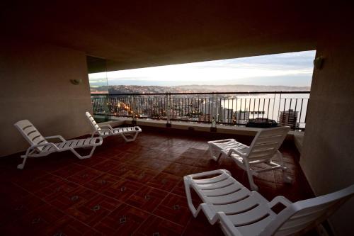a balcony with chairs and a view of a city at Departamentos Alto Libertad in Viña del Mar