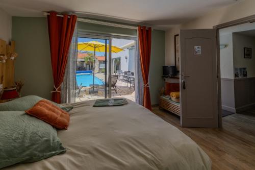 a bedroom with a large bed with a view of a pool at Les Pertuis Rochelais in Périgny