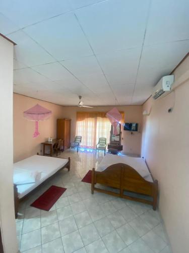 a bedroom with two beds and a room with two tables at Mayura Beach Resort Matara in Matara