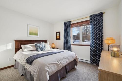 a bedroom with a bed and a window at Cozy Golfside Oasis Fireplace and Terrace in Mont-Tremblant