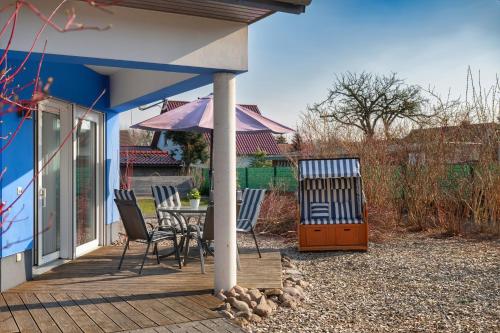 a patio with a table and chairs and an umbrella at Bungalow Spinnaker in Ueckermünde