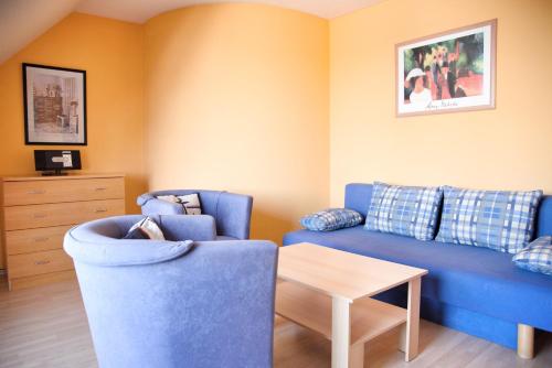 a living room with a blue couch and a table at Lagunenstadt am Haff - Fewo 67 Vorstag in Ueckermünde