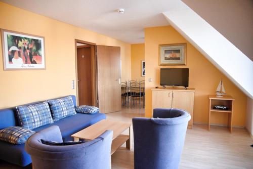 a living room with a blue couch and chairs at Lagunenstadt am Haff - Fewo 67 Vorstag in Ueckermünde