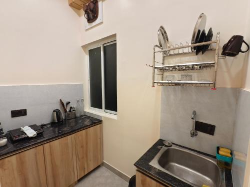 a small kitchen with a sink and a window at Cordial Host in Guwahati