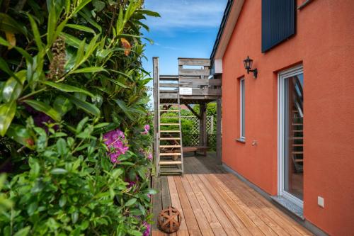 a wooden deck with a ladder next to a building at Mö 71-Inselblick in Mönkebude
