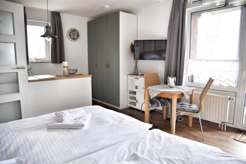 a bedroom with a bed and a table and a desk at Lagunenstadt am Haff - Fewo 166 Nautilus in Ueckermünde