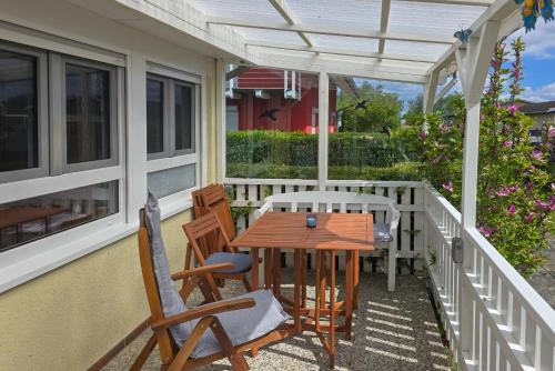 a porch with a wooden table and chairs on it at Turmhaus Mönkebude in Mönkebude