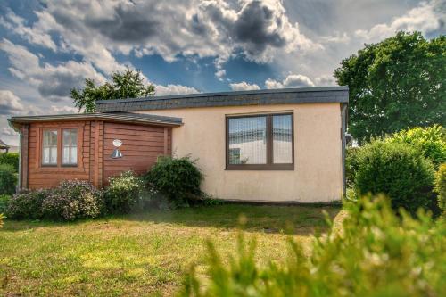 a small house in a yard with a field at Strandhaus 38 in Mönkebude