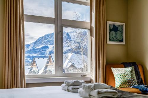 a bedroom with a window with a view of a mountain at Stylish Mountain View Condo with Gym in Canmore