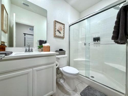 a bathroom with a toilet and a glass shower at Attached Guest House in Woodland