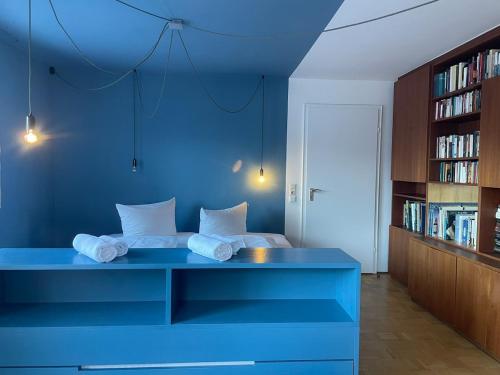 a blue room with a bed and a book shelf at King Ludwig's Old Neighbour in Schwangau