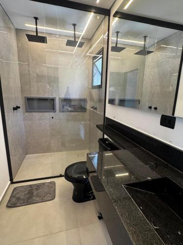 a bathroom with a shower and a toilet and a sink at Resilience Igaratá in Igaratá