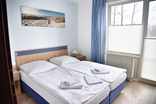 a bedroom with a bed with white sheets and pillows at Lagunenstadt am Haff - Fewo 4 Muschel in Ueckermünde