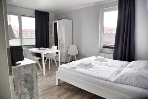 a bedroom with a bed and a table and a desk at Lagunenstadt am Haff - Fewo 181 Kogge in Ueckermünde