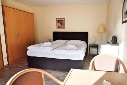 a bedroom with a bed and a table and chairs at Lagunenstadt am Haff - Fewo 196 Gaffel in Ueckermünde
