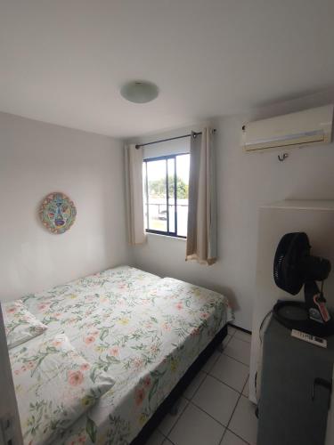 a small bedroom with a bed and a window at Cumbuco Geek House in Cumbuco
