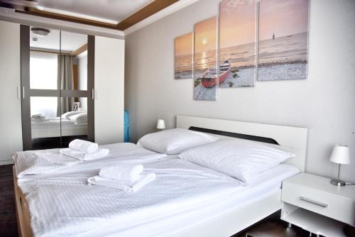 a bedroom with a white bed with two towels on it at Lagunenstadt am Haff - Fewo 72 Flip in Ueckermünde