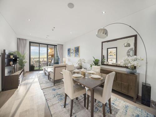 a dining room and living room with a table and chairs at Livin' Holidays - 1 BR - Anantara Lagoon Stay in Dubai