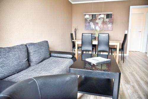a living room with a couch and a table with chairs at Lagunenstadt am Haff - 119 Marina in Ueckermünde