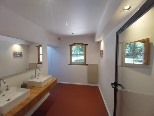a bathroom with two sinks and two mirrors at Posada La Celia in Eugenio Bustos
