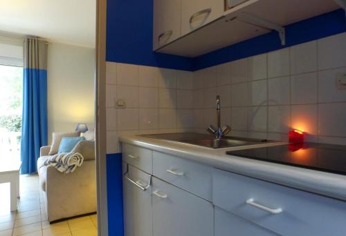 a kitchen with a sink and a blue wall at VVF Piriac-sur-Mer Bretagne Sud in Piriac-sur-Mer