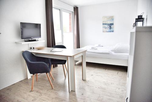 a room with a desk with two chairs and a bed at Lagunenstadt am Haff - 189 Stromer in Ueckermünde